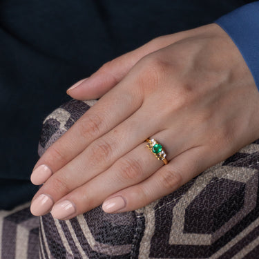 Natural emerald 0.63ct and diamond ring in 18k yellow gold worn on hand